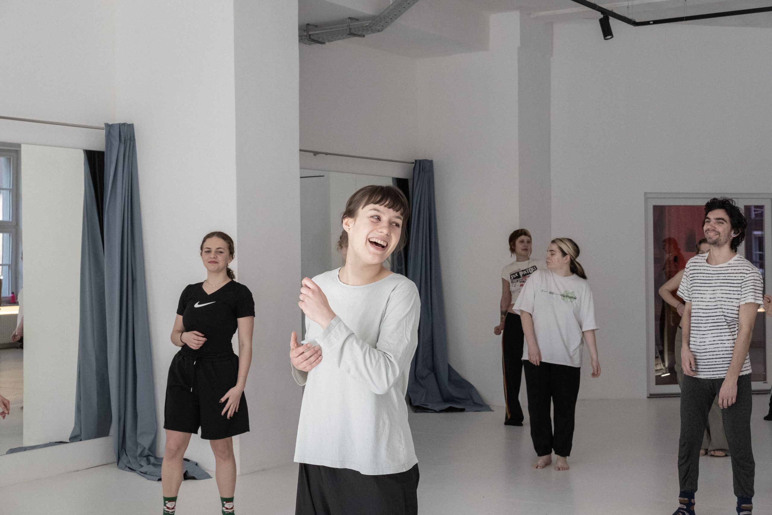 Uczestnicy zajęć Impro & Contemporary w Studio Nieznane w Poznaniu podczas ćwiczeń ruchowych w jasnej sali.